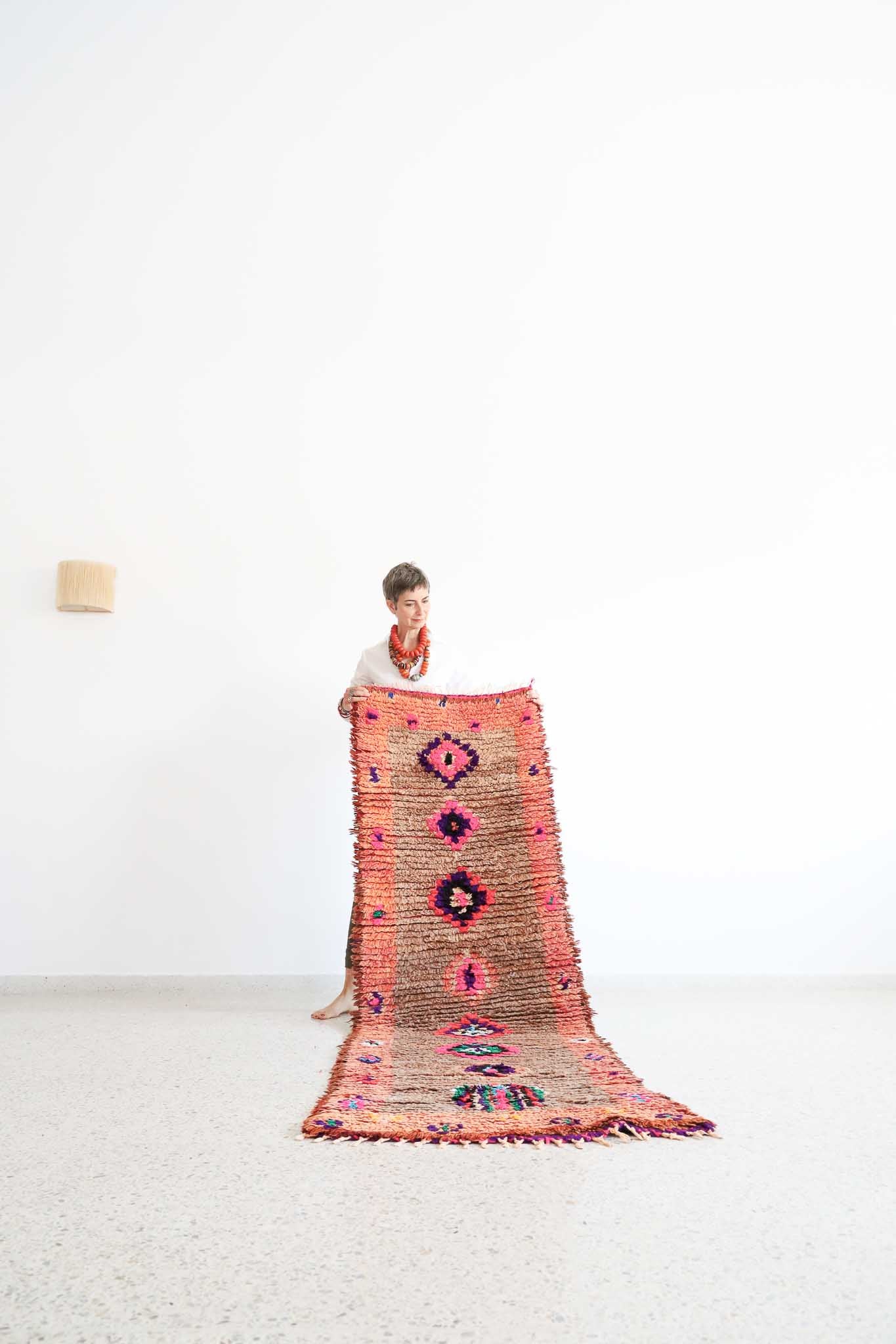 A Moroccan rug in the style of a Boucherouite. Handmade in wool and some cotton threads. Lovely earthy tones background enhanced by diamonds in bold colors. A truly interesting piece with lovely texture .